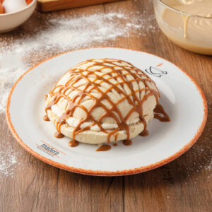 Concha rellena de nata y bañada con dulce de leche